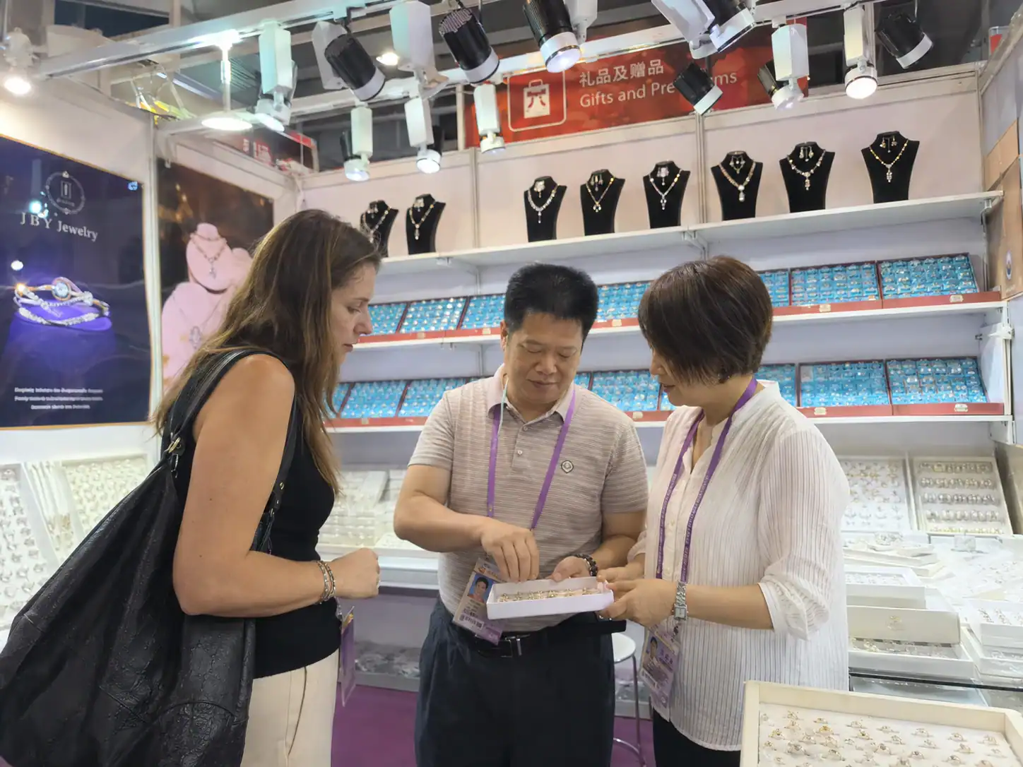 Jewelry buyer reviewing products with JBY at trade show